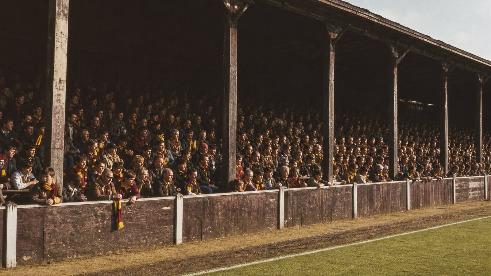 A calm crowd in a fictional ageing British timber football stand before a 1985 match