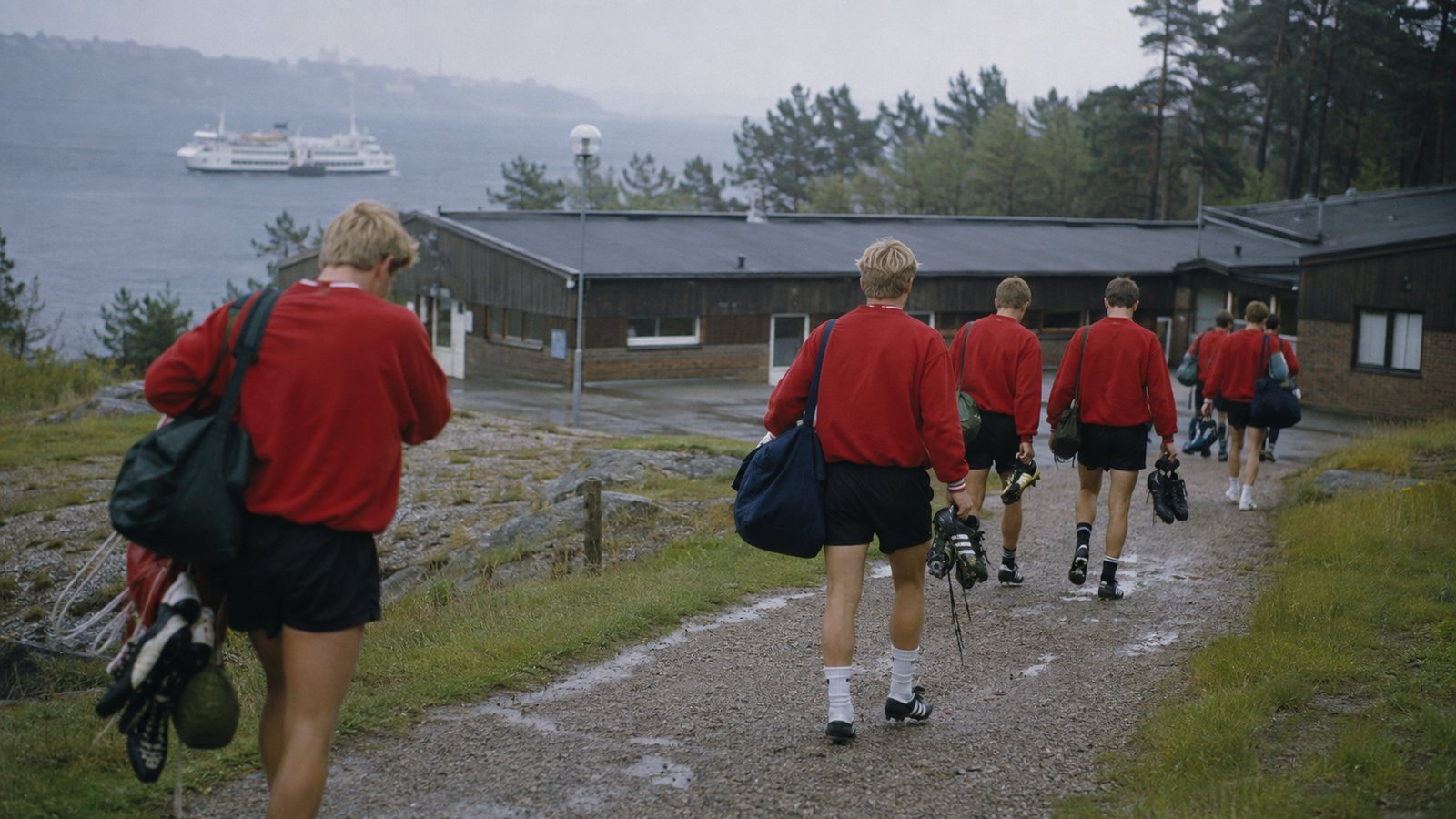 Fictional Danish footballers receiving a late tournament call beside half-packed summer bags